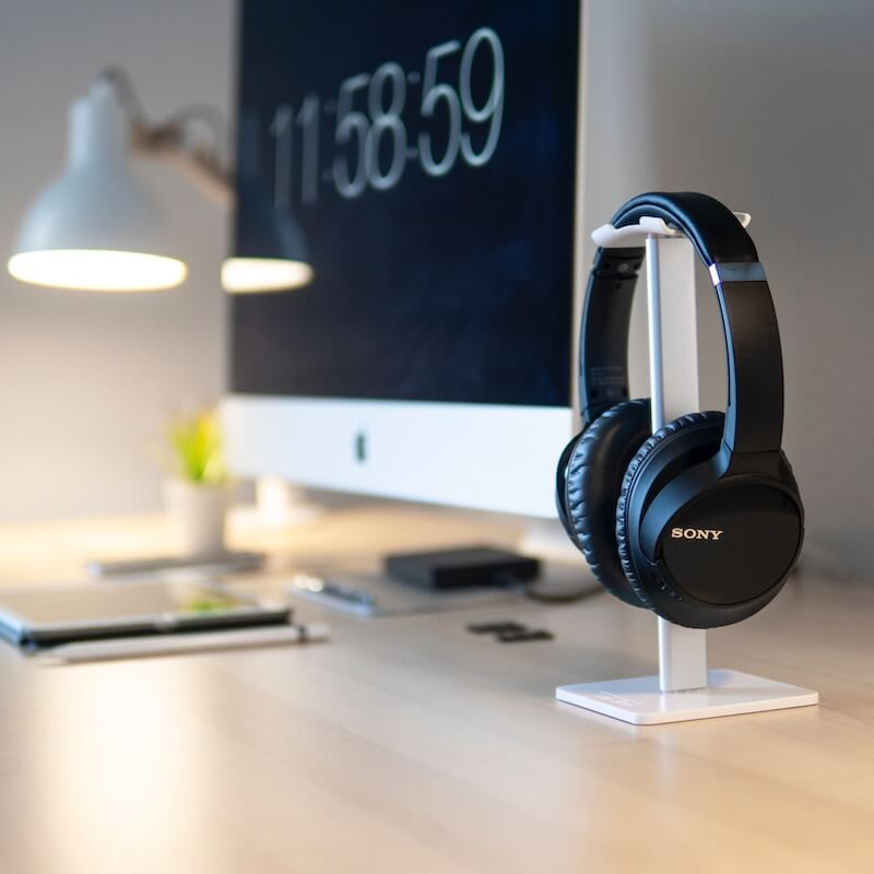 Black Sony Headphones on headphone stand next to iMac