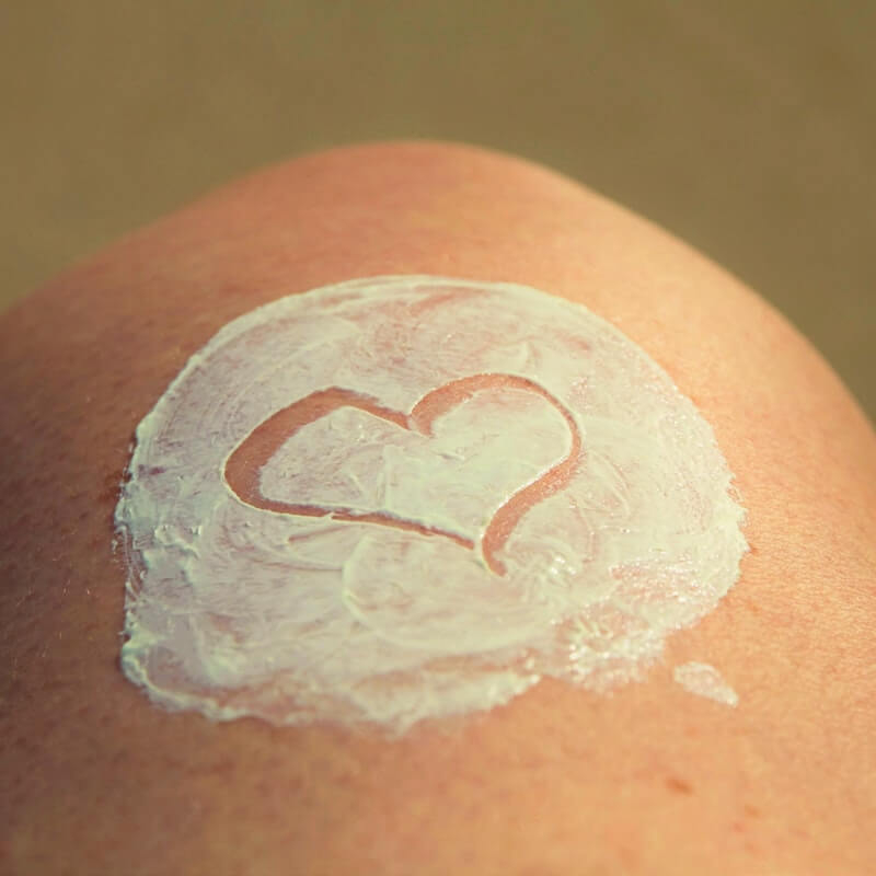 Sun Cream on leg with heart shape